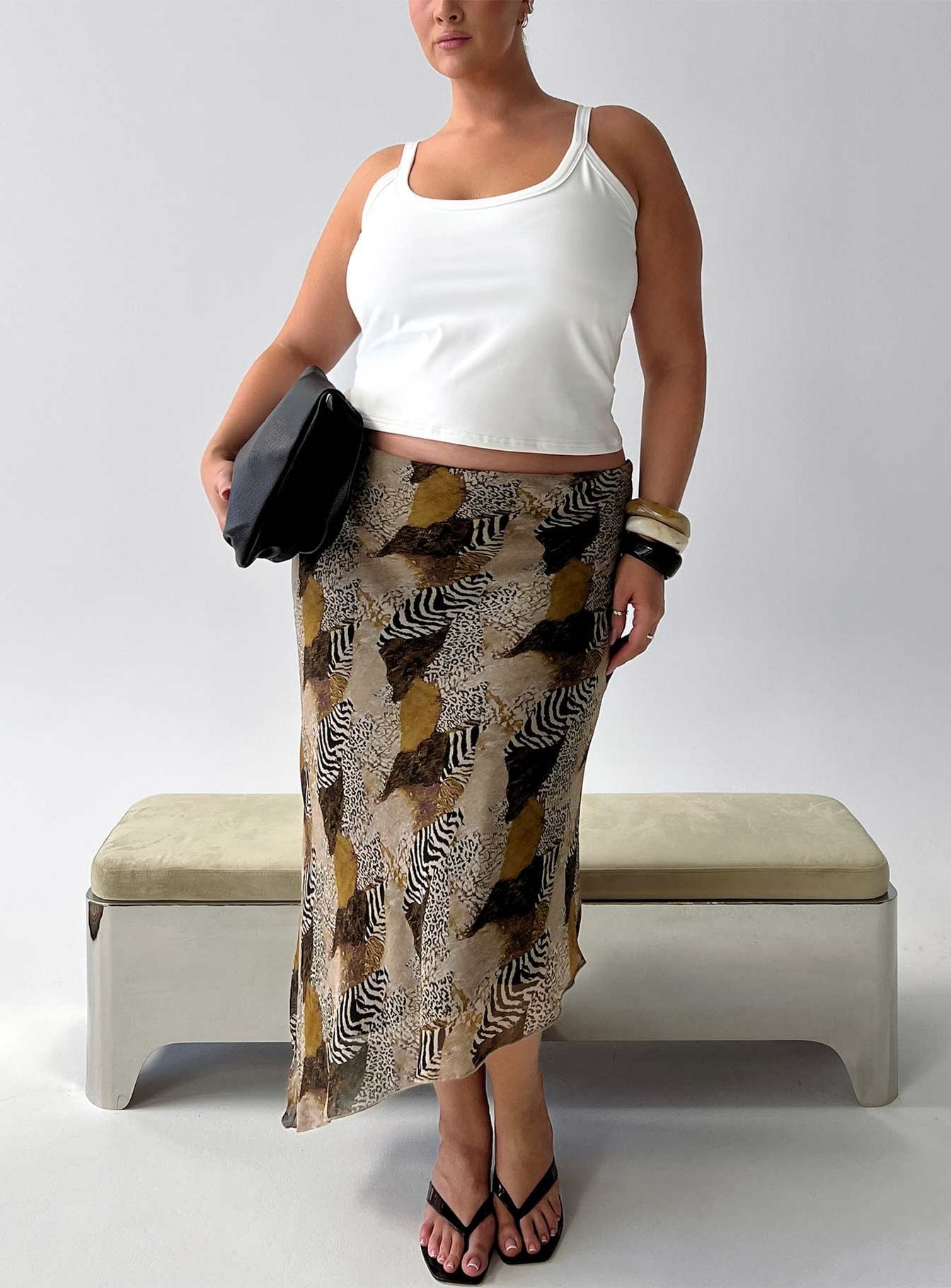 Showcasing the Suella Asymmetrical Midi Skirt Animal Multi Curve in womens-skirts with fitted silhouette and frayed hem in animal-leopard print front view of model wearing Princess Polly