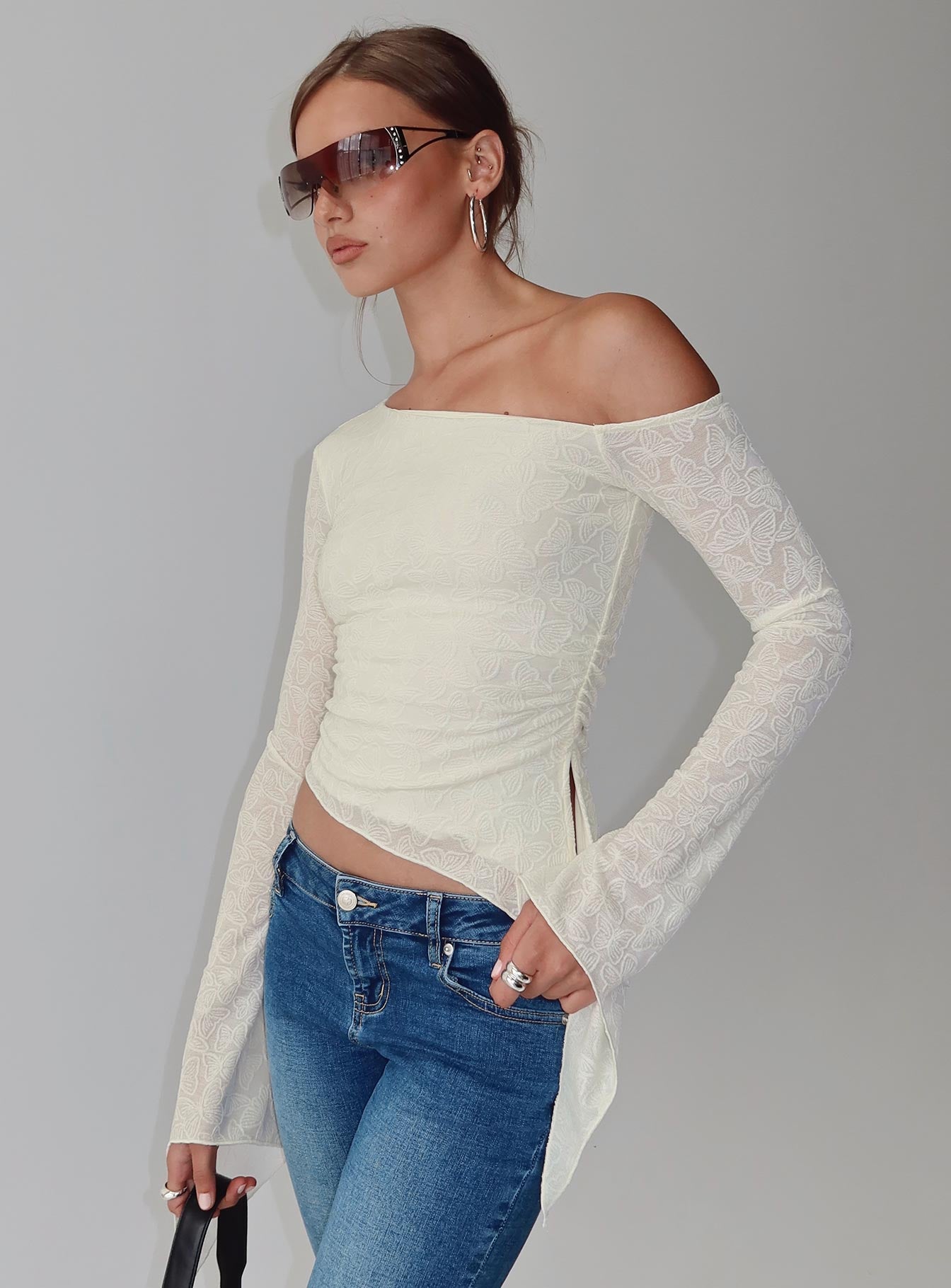 back view of model wearing Princess Polly Face Card Long Sleeve Top Cream Full Sleeves Asymmetric Neckline 