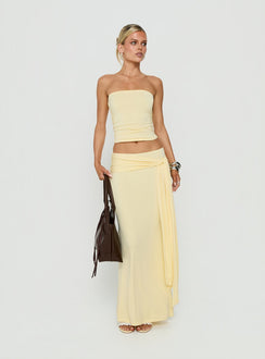 Showcasing the Aymee Tie Detail Maxi Skirt in Yellow, a women's skirt with relaxed fit, lace hem, solid print, aline shape, and wrap details front view of model wearing Princess Polly