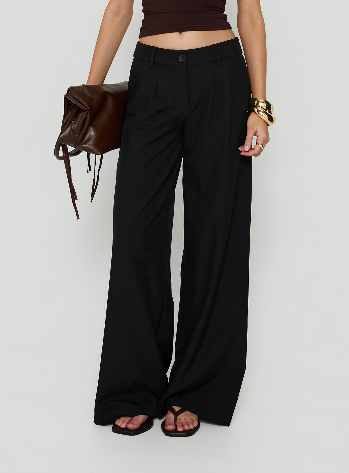 Showcasing the Archer Mid Rise Baggy Pants Black in womens-regular-pants with pleated details front view of model wearing Princess Polly