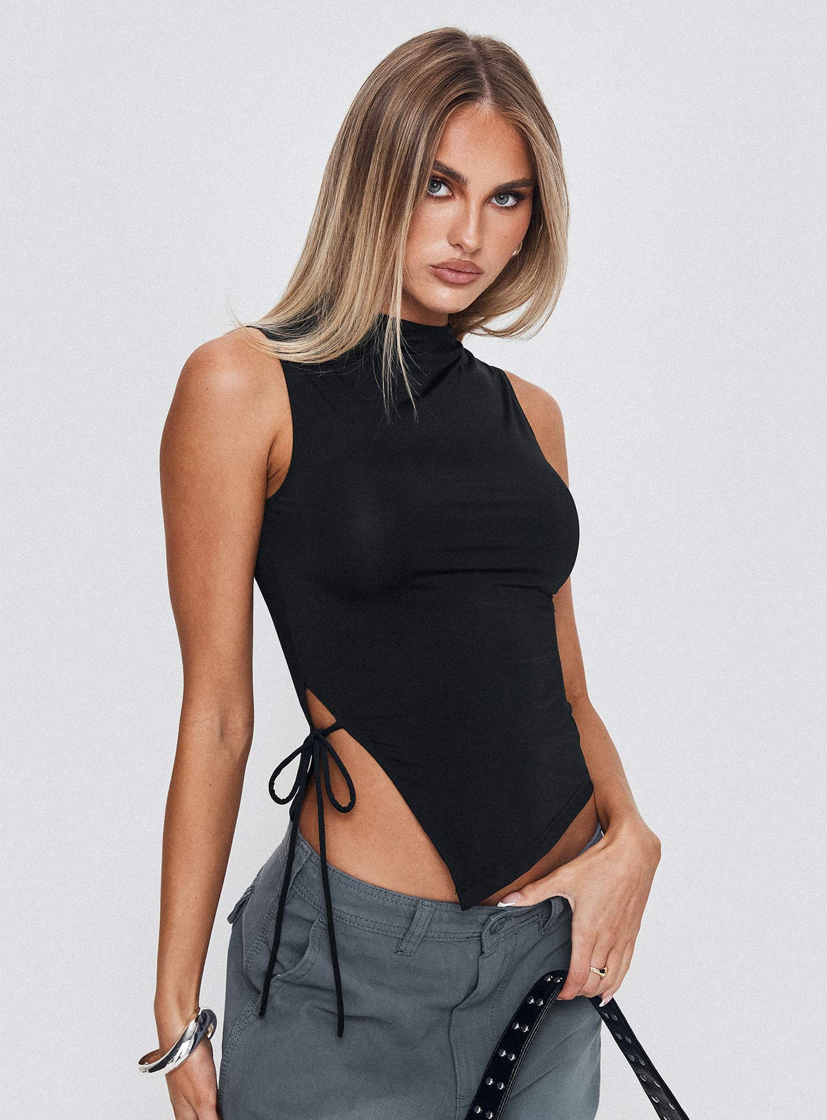 side view of model wearing Princess Polly Solarah Tie Side Top Black Sleeveless High Neck 
