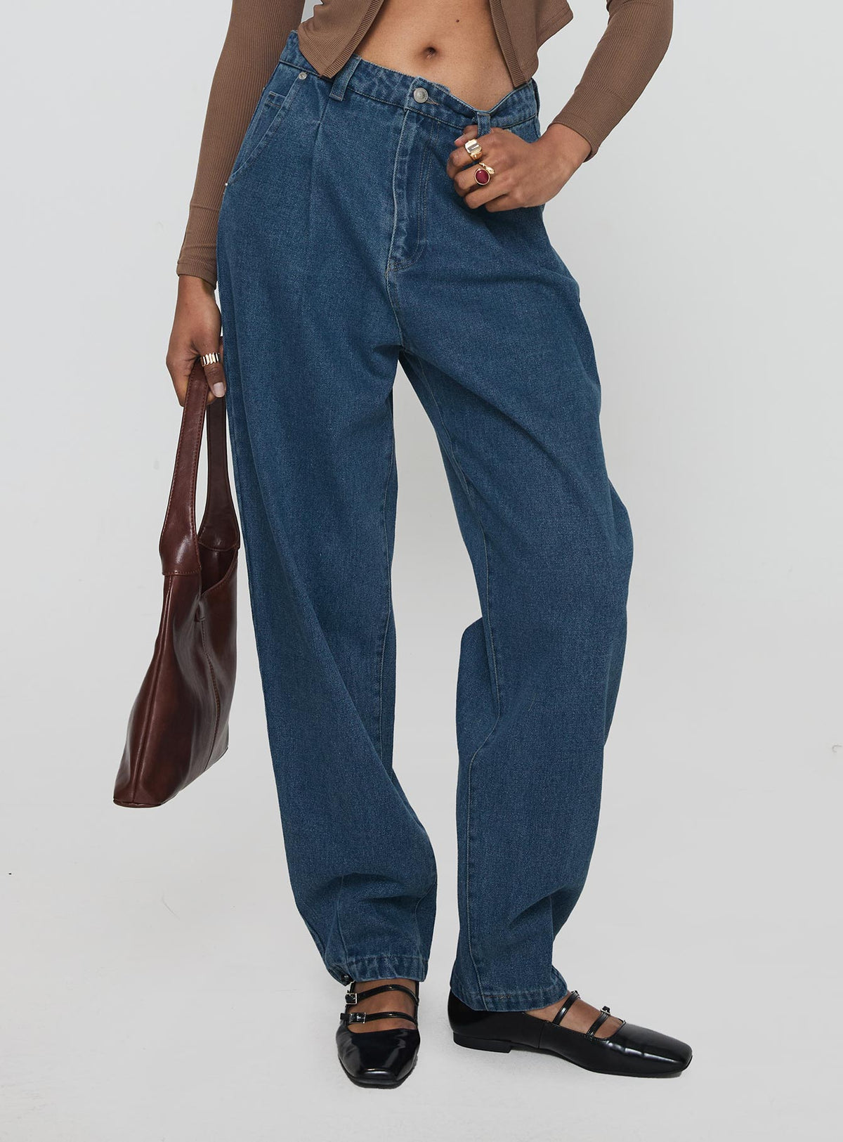 side view of model wearing Princess Polly Forestier Pin Tuck Jeans Mid Blue High Waisted 