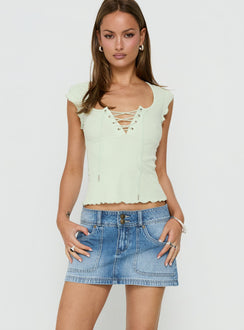 Designed with the Moving Fast Denim Mini Skirt Mid Blue Wash in womens-skirts featuring mini length detail view of model wearing Princess Polly