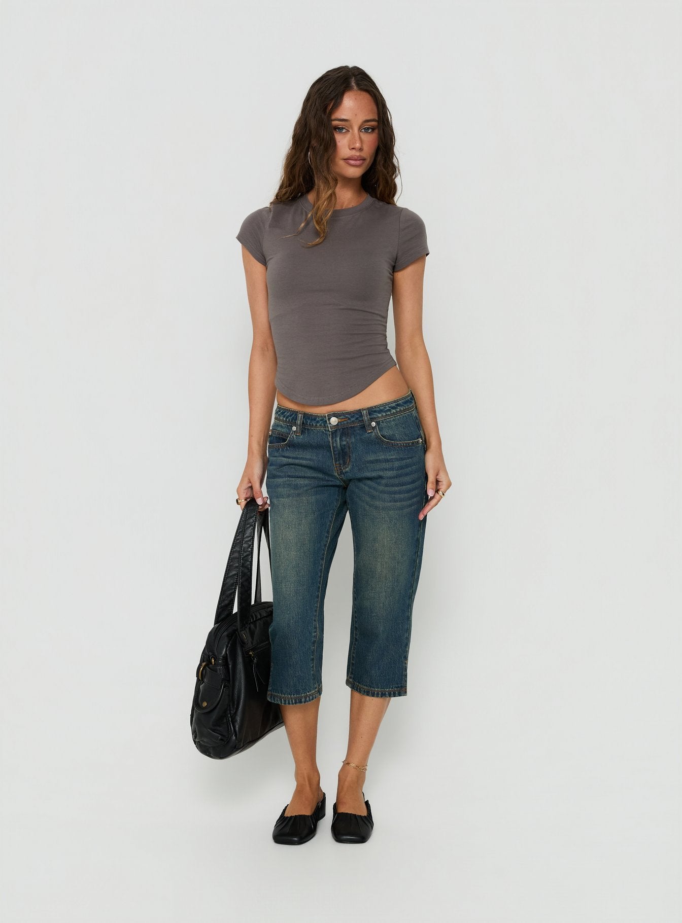 Showcasing the Ceilea Ultra Low Rise Denim Capri Pants Dirty Blue in womens regular pants with low-rise waist front view of model wearing Princess Polly