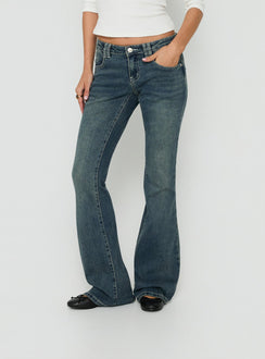 A detailed look at Clynee Ultra Low Rise Bootleg Jeans Dirty Blue womens-jeans with low-rise waist side view of model wearing Princess Polly