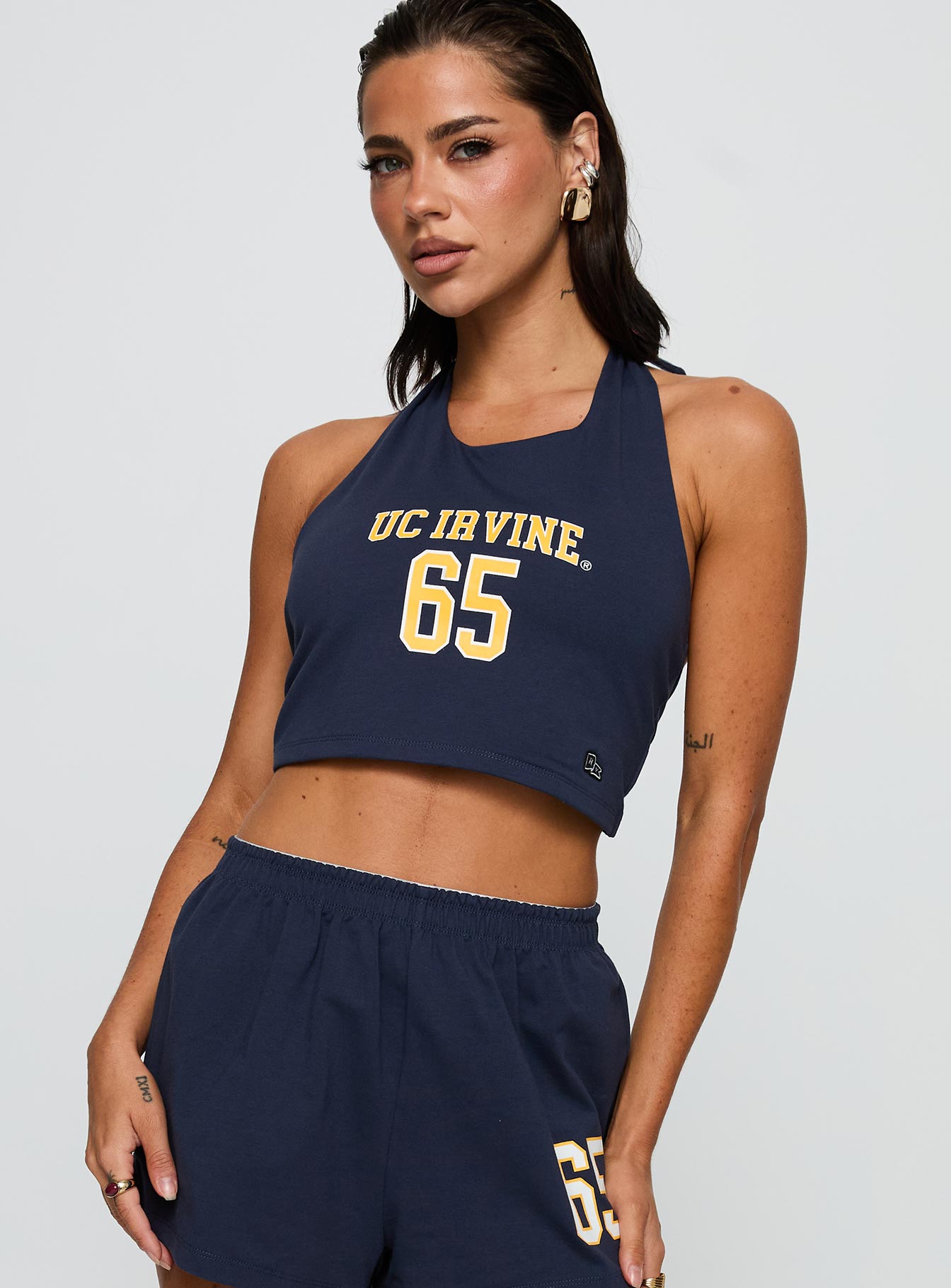 side view of model wearing Princess Polly UC Irvine Tailgate Halter Top Blue Sleeveless Scoop Neck 