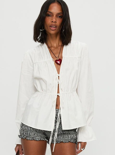 front view of model wearing Princess Polly Scarlotte Bow Tie Top White Full Sleeves V-Neck 