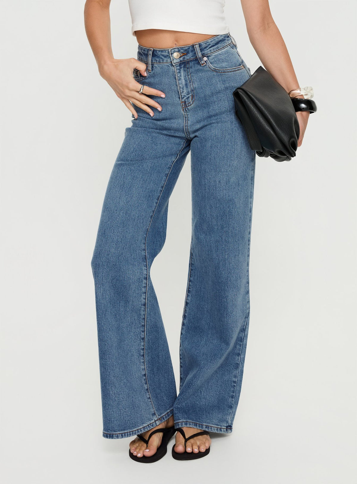 front view of model wearing Princess Polly Thearlie High Rise Flared Jeans Mid Blue Wash High Rise Jeans 