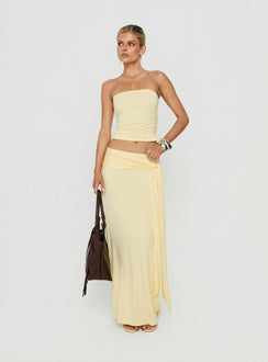 Featuring the Aymee Tie Detail Maxi Skirt in Yellow, a women's skirt with relaxed fit, lace hem, solid print, aline shape, and wrap details side view of model wearing Princess Polly