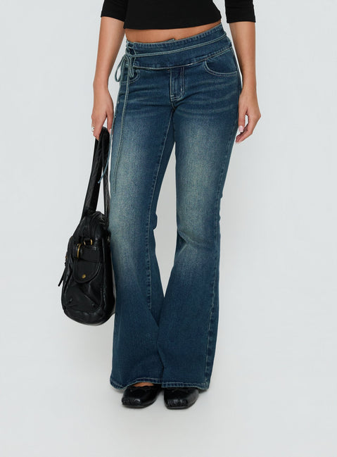 Crafted from Runa Low Rise Tie Side Jeans Mid Blue Wash featuring womens-jeans with flared wide-leg silhouette Princess Polly