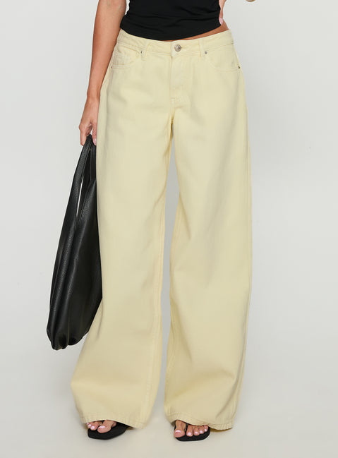 side view of model wearing Princess Polly Ramos Low Rise Wide Leg Jeans Butter Lemon Low Rise Jeans 