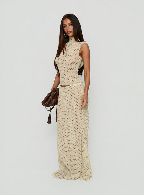 Crafted from premium fabric, the Ford Maxi Skirt Butter Chocolate Polka Dot in womens-skirts with a maxi length design side view of model wearing Princess Polly