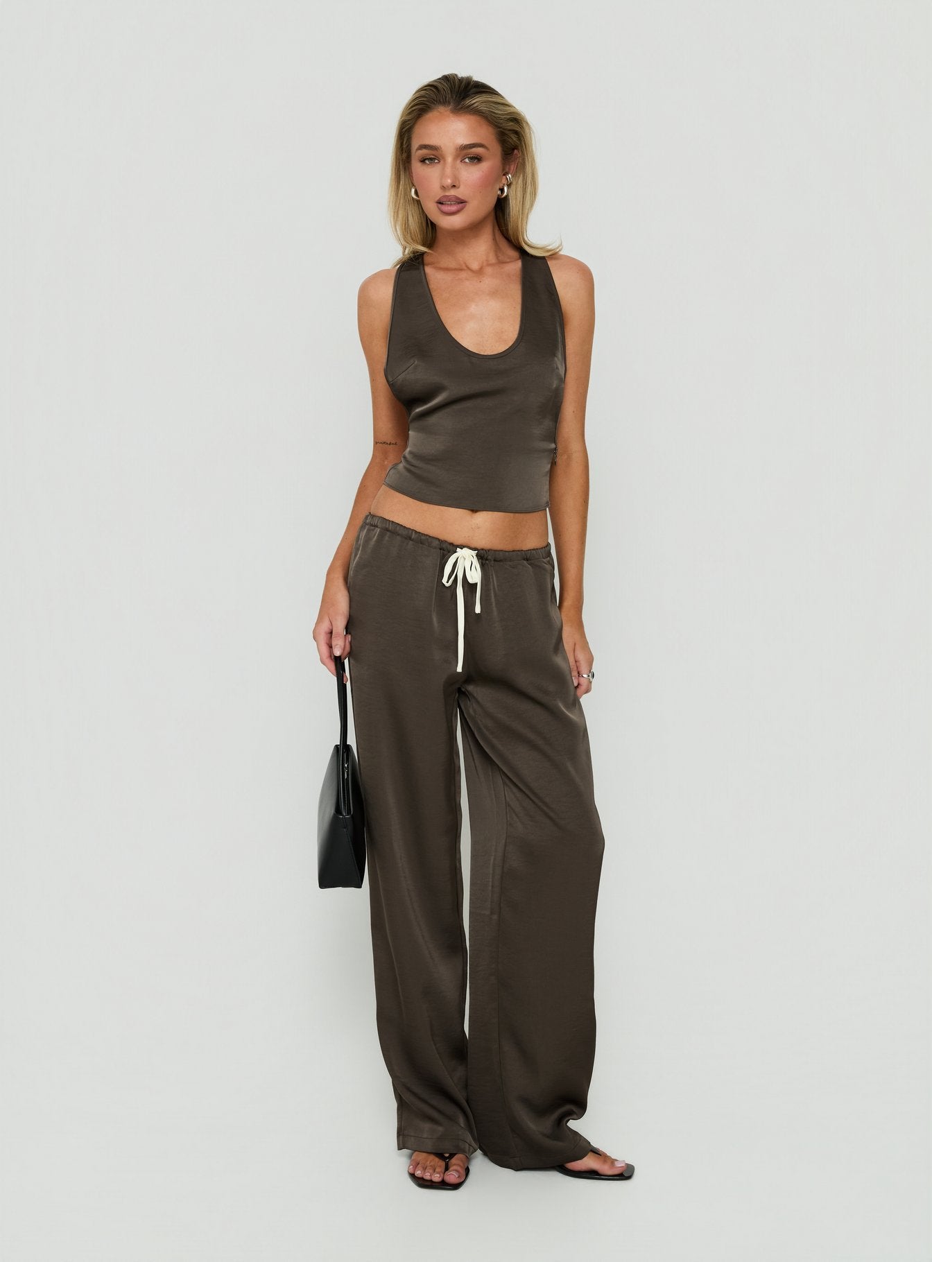 Discover the Dialled Up Tie Waist Satin Pants Mocha in womens regular pants with mid-rise design front view of model wearing