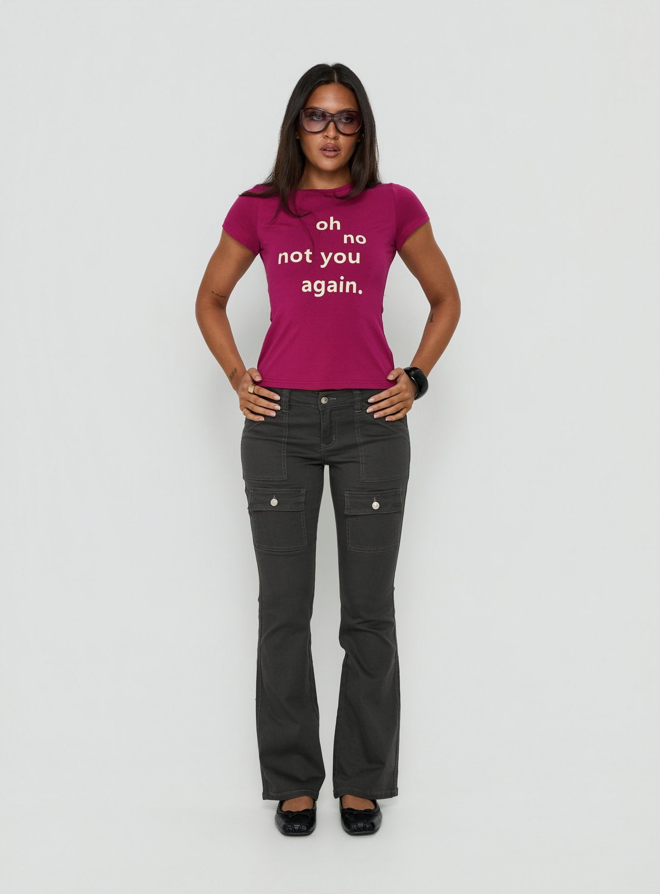 Crafted from charcoal fabric, the Trust Fund Low Rise Bootleg Cargo Pants in womens regular pants, front view of model wearing Princess Polly