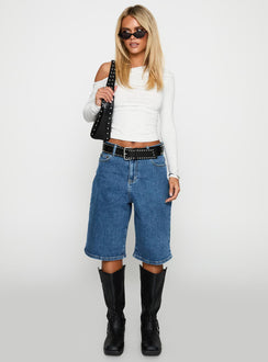 side view of model wearing Princess Polly Retro Dream Mid Rise Longline Denim Shorts Mid Wash Low Rise Shorts 
