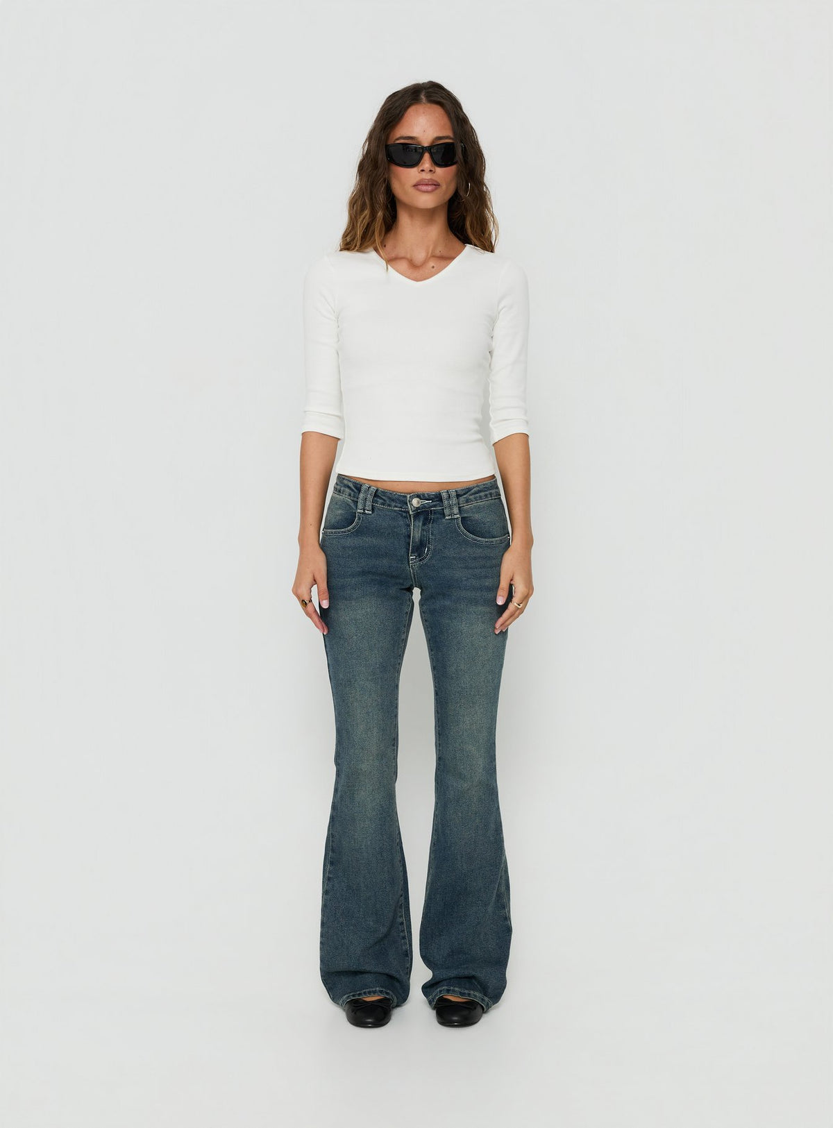 Showcasing the Clynee Ultra Low Rise Bootleg Jeans Dirty Blue in womens-jeans with low-rise waist front view of model wearing Princess Polly