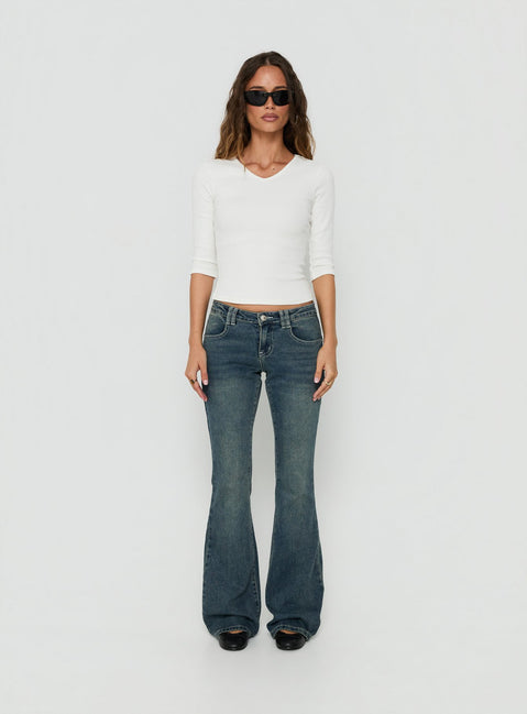 Showcasing the Clynee Ultra Low Rise Bootleg Jeans Dirty Blue in womens-jeans with low-rise waist front view of model wearing Princess Polly