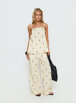 Featuring Bellara Tie Waist Pants Yellow Polka womens regular pants in polkadot print with mid-rise and wide-leg silhouette front view of model wearing Princess Polly