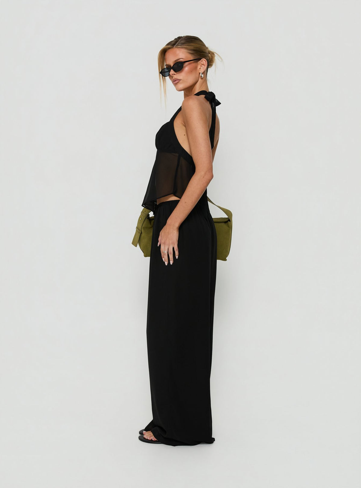 Showcasing the Finesse Pants Black in womens-regular-pants with mid-rise wide-leg styling side view of model wearing Princess Polly