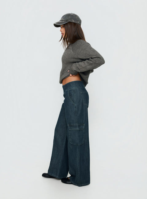 Crafted with the Nikoletta Mid Rise Wide Leg Cargo Jeans Dark Blue Wash in womens-jeans with mid-rise side view of model wearing