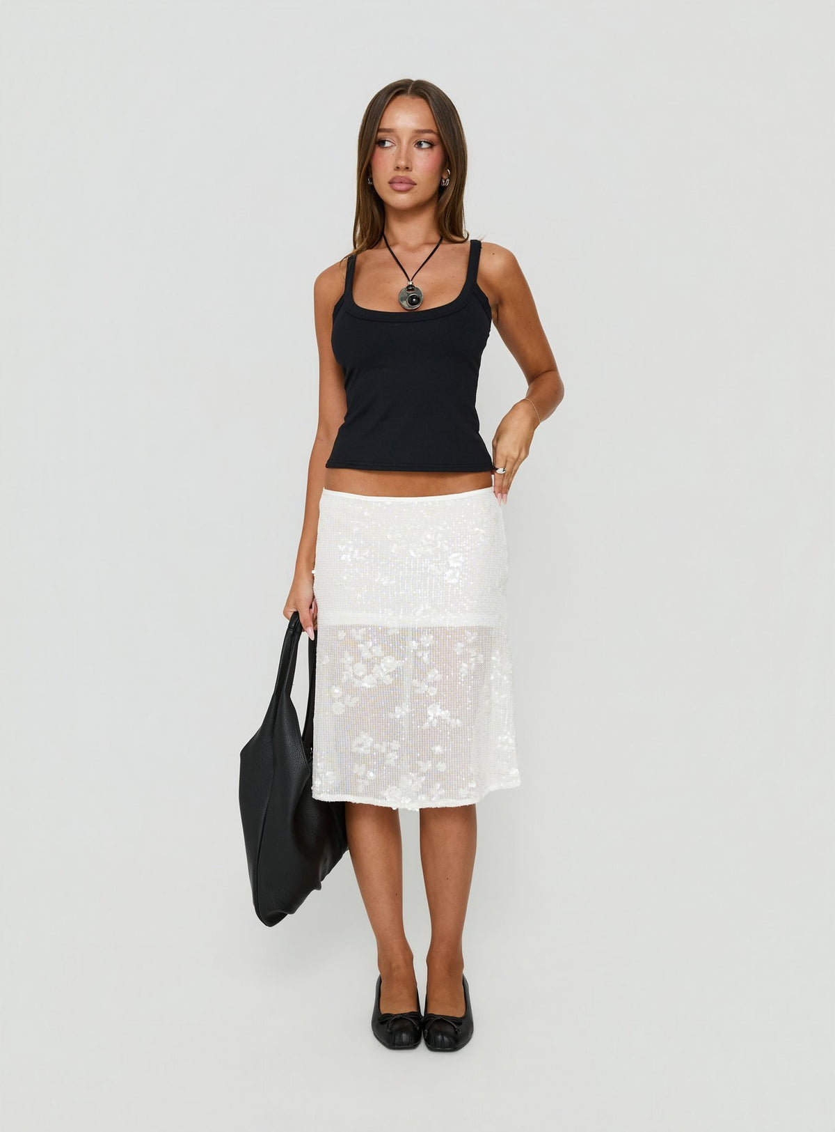 Showcasing the Heart Stealer Sheer Sequin Midi Skirt in White with fitted a-line shape and frayed hem front view of model wearing Princess Polly