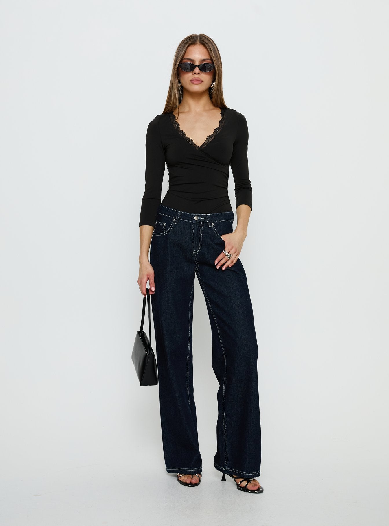 side view of model wearing Princess Polly Lyselle Wrap Detail 3/4 Sleeve Bodysuit Black Quarter Sleeve 