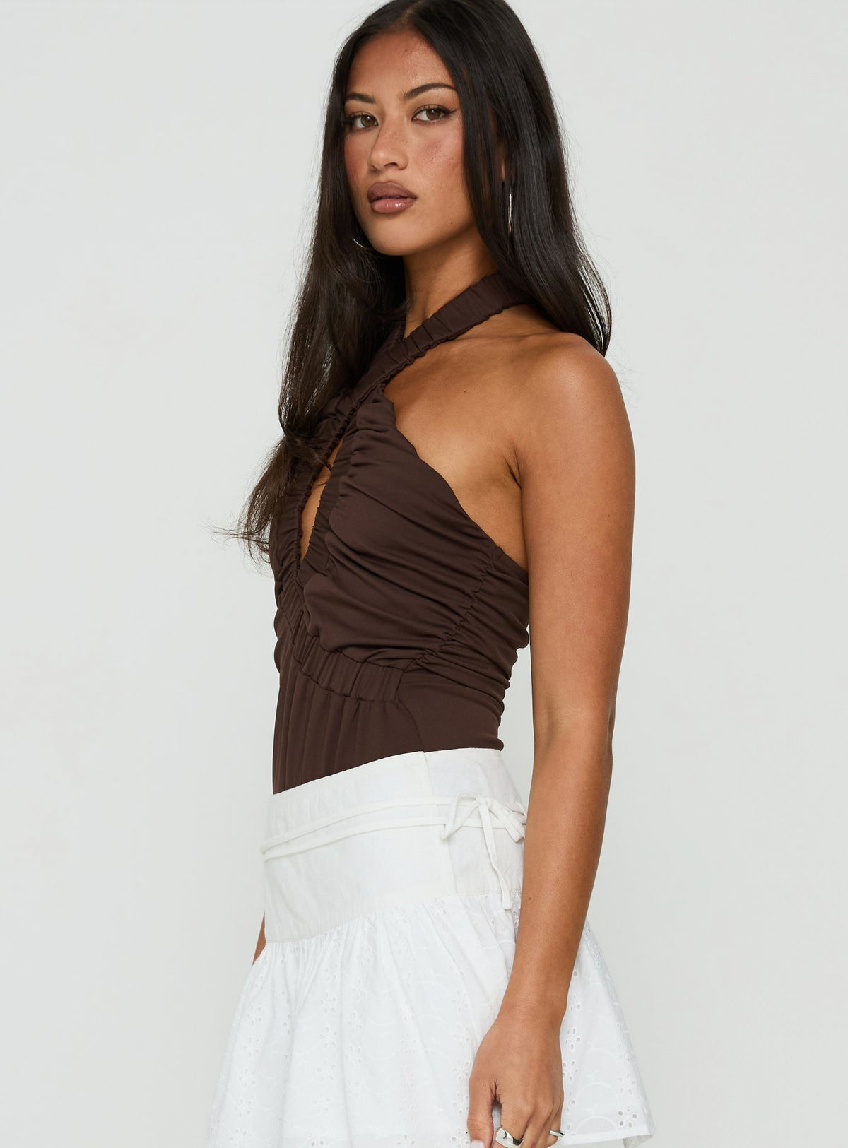 Featuring the Pettra Halter Neck Bodysuit Brown womens-bodysuit with sleeveless cut side view of model wearing Princess Polly