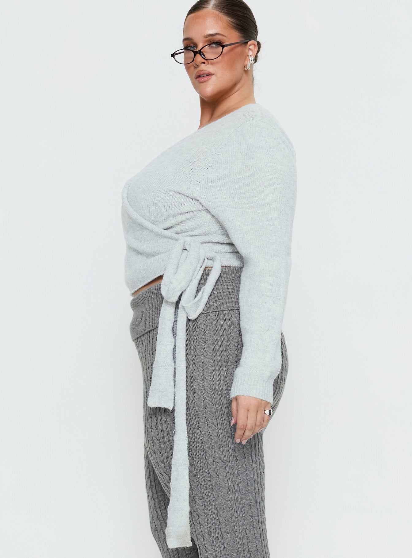 Designed with the Tonee Wrap Knit Cardigan Grey Curve in a short length womens jumper with v-neck and oversized fit side view of model wearing Princess Polly