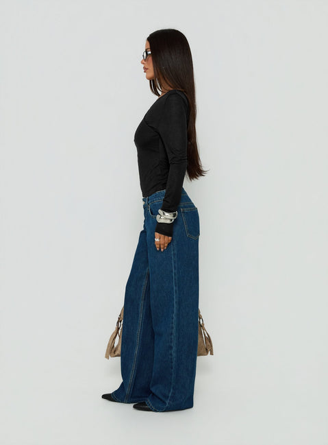 Showcasing Tidal Wave Low Rise Straight Leg Jeans Dark Blue Wash in womens-jeans side view of model wearing Princess Polly