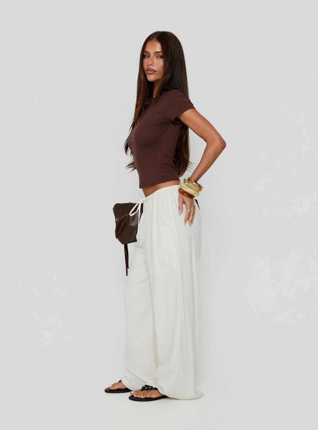 Featuring the Peacemaker Tie Waist Relaxed Pants Off-White in womens regular pants with mid-rise styling side view of model wearing Princess Polly