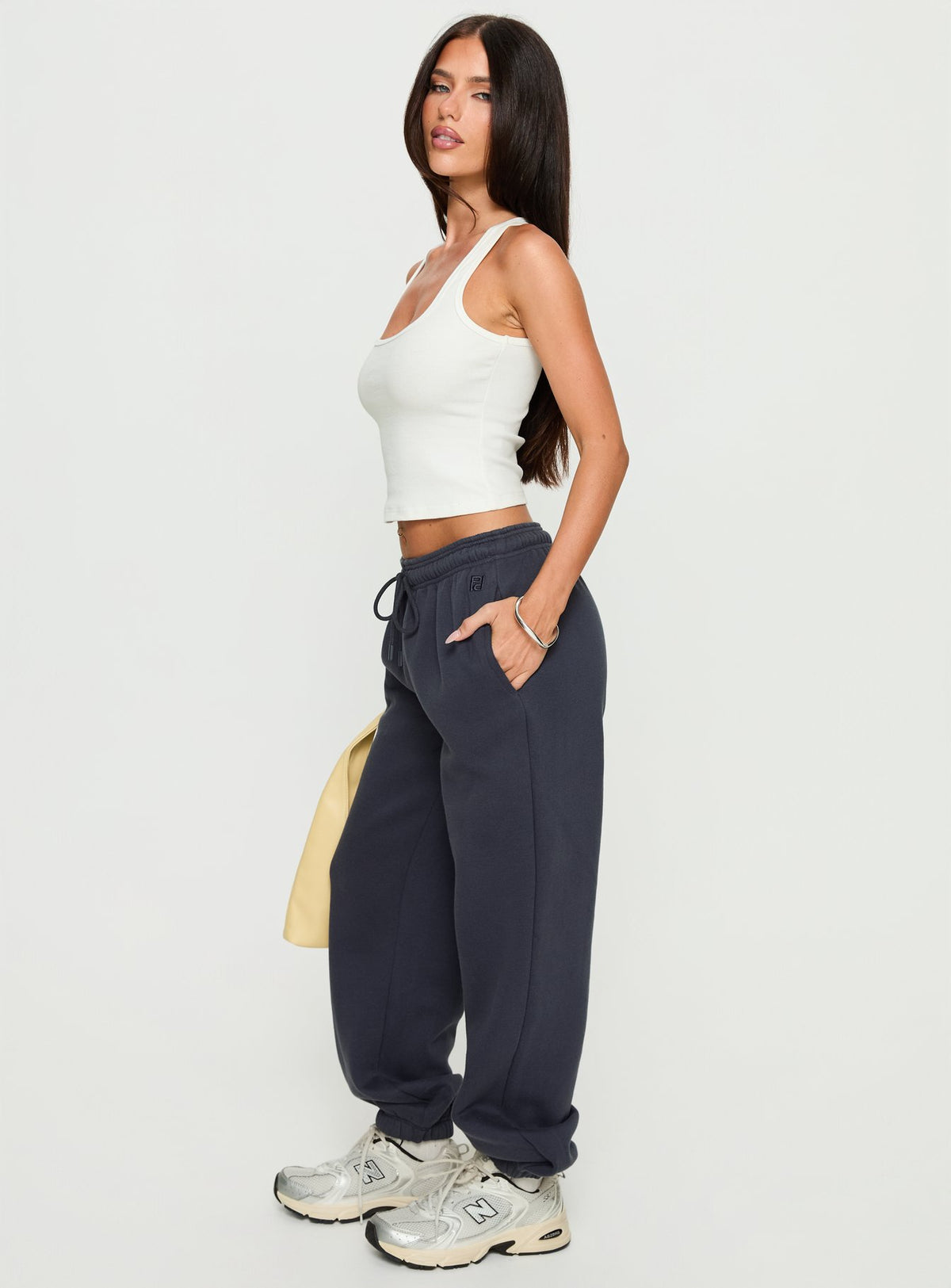 side view of model wearing Princess Polly Caspa Dream Fleece Oversized Ankle Cuff Jogger Navy High Rise Pants 