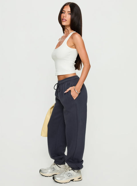 side view of model wearing Princess Polly Caspa Dream Fleece Oversized Ankle Cuff Jogger Navy High Rise Pants 