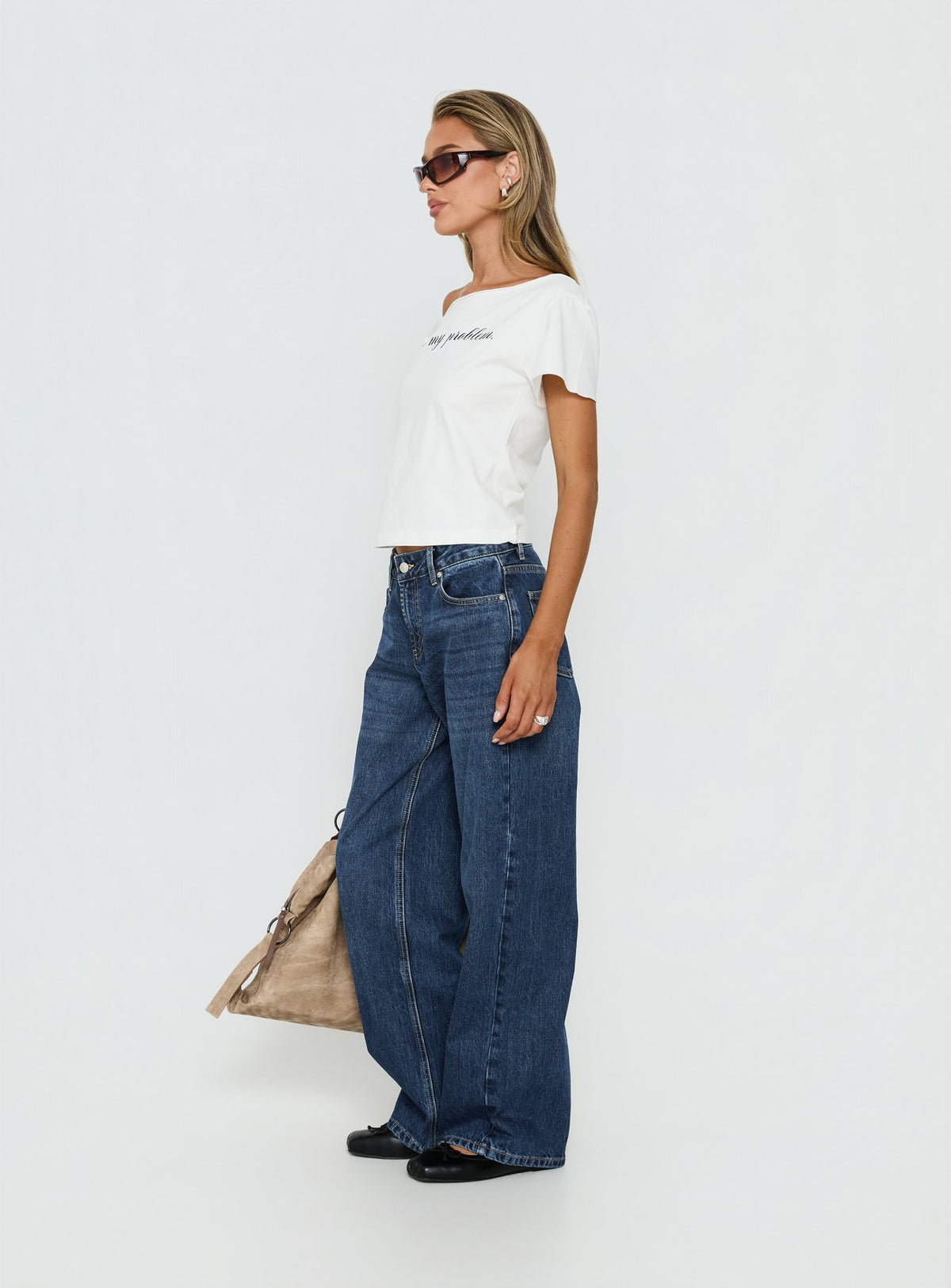 side view of model wearing Princess Polly Serenitia Mid Rise Straight Leg Relaxed Jeans Dark Blue Wash Mid Rise Jeans 