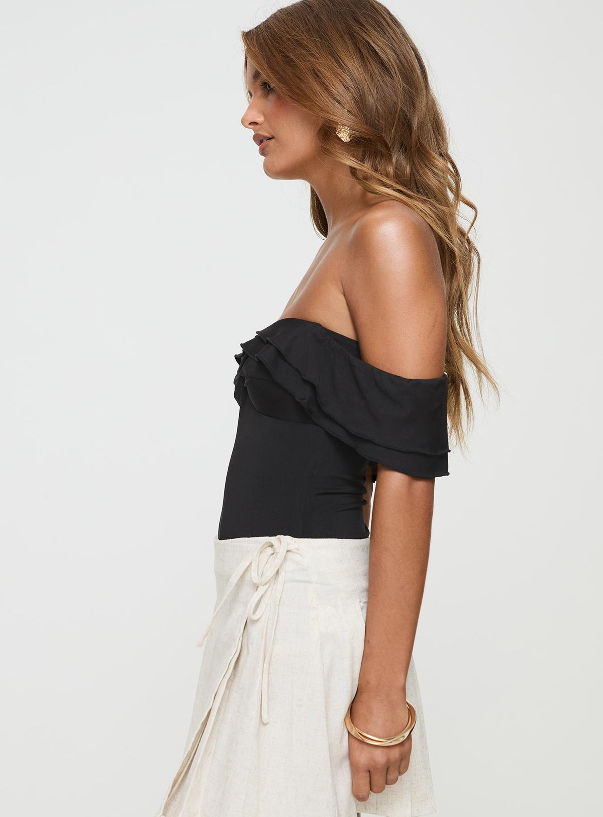 side view of model wearing Princess Polly Coming Back Ruffle Bodysuit Black Sleeveless 