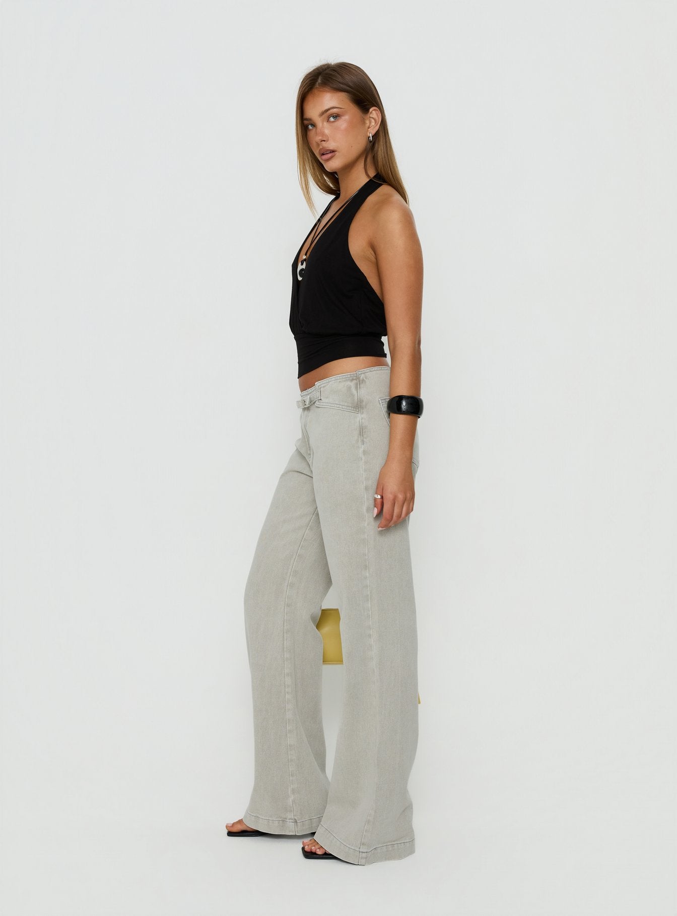 Showcasing the Slow Ride Mid Rise Bootleg Belted Jeans Desert Grey in womens-jeans side view of model wearing Princess Polly