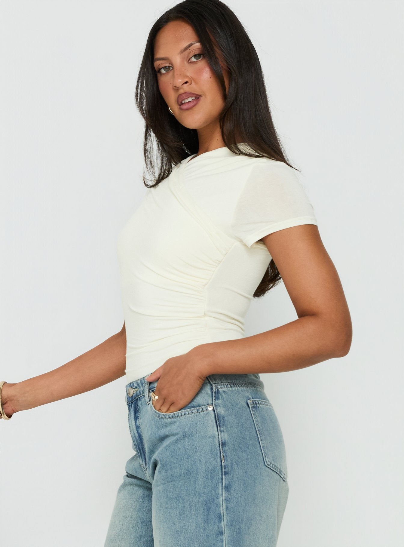 Featuring the Odettea Cross Front Short Sleeve Bodysuit in Cream with short sleeves side view of model wearing Princess Polly