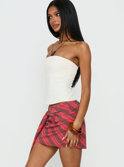   side view of model wearing Princess Polly Lindsy Tie Side Mini Skirt Red Multi Mini Skirts 