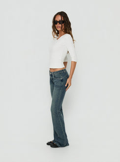A detailed look at Clynee Ultra Low Rise Bootleg Jeans Dirty Blue womens-jeans with low-rise waist side view of model wearing Princess Polly