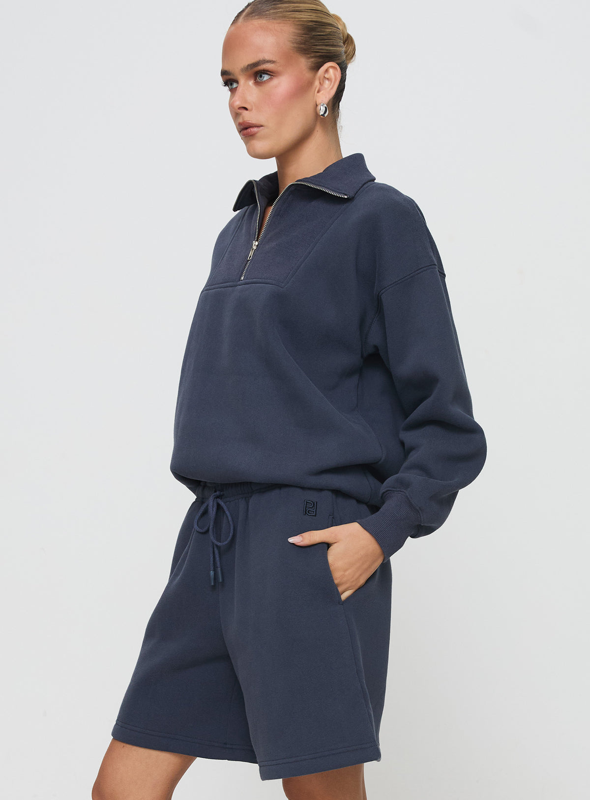 side view of model wearing Princess Polly Dream Fleece Longline Shorts Navy High Waisted Shorts 