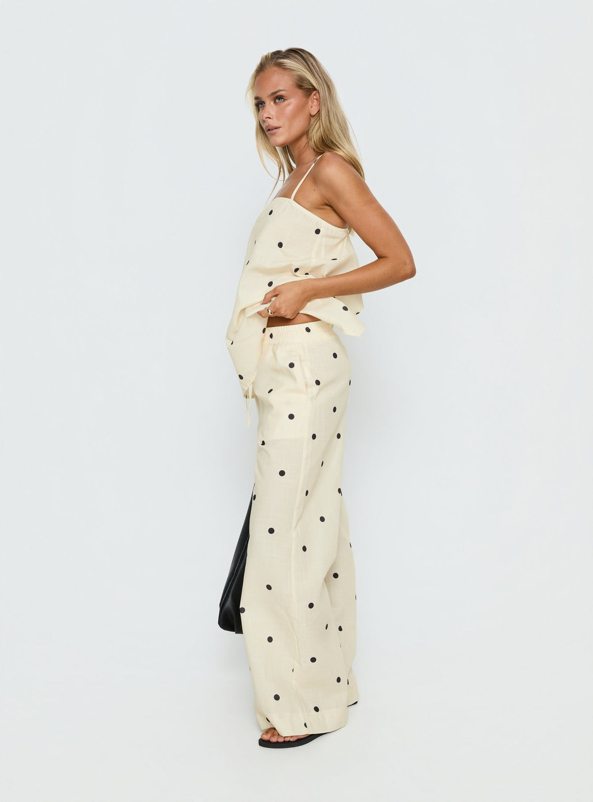 Designed in cornsilk with black polkadot, Bellara Tie Waist Pants Yellow Polka womens regular pants feature a mid-rise belt side view of model wearing Princess Polly
