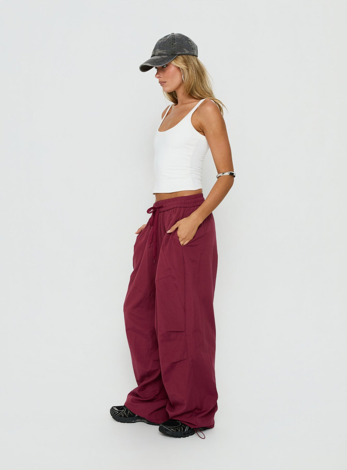 Explore the Mankind Baggy Cargo Pants Red womens-regular-pants featuring mid-rise maroon side view of model wearing Princess Polly
