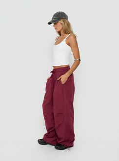 Explore the Mankind Baggy Cargo Pants Red womens-regular-pants featuring mid-rise maroon side view of model wearing Princess Polly