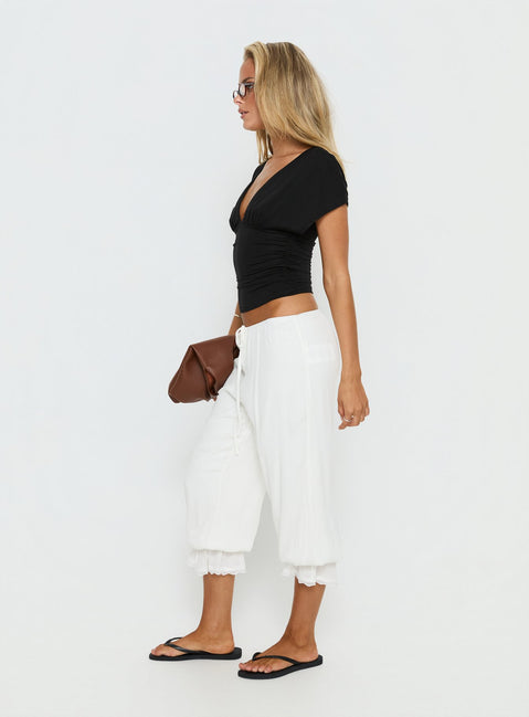 side view of model wearing Princess Polly Basma Bloomer Trouser Pants Rayon White Mid Rise Pants 