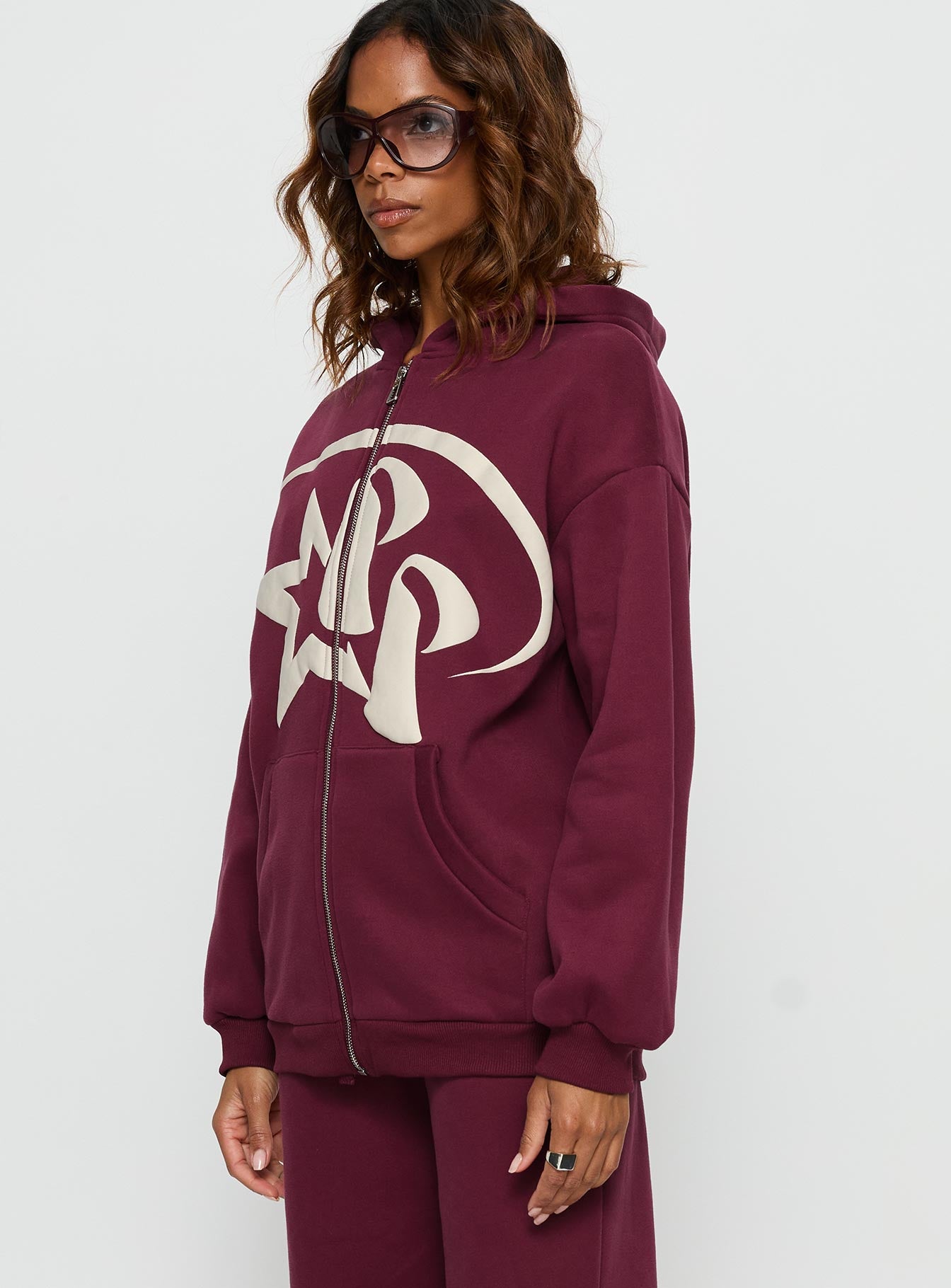 Featuring the Stargirl Zip Through Jumper in burgundy womens jumpers with long oversized fit, graphic print and hood side view of model wearing Princess Polly