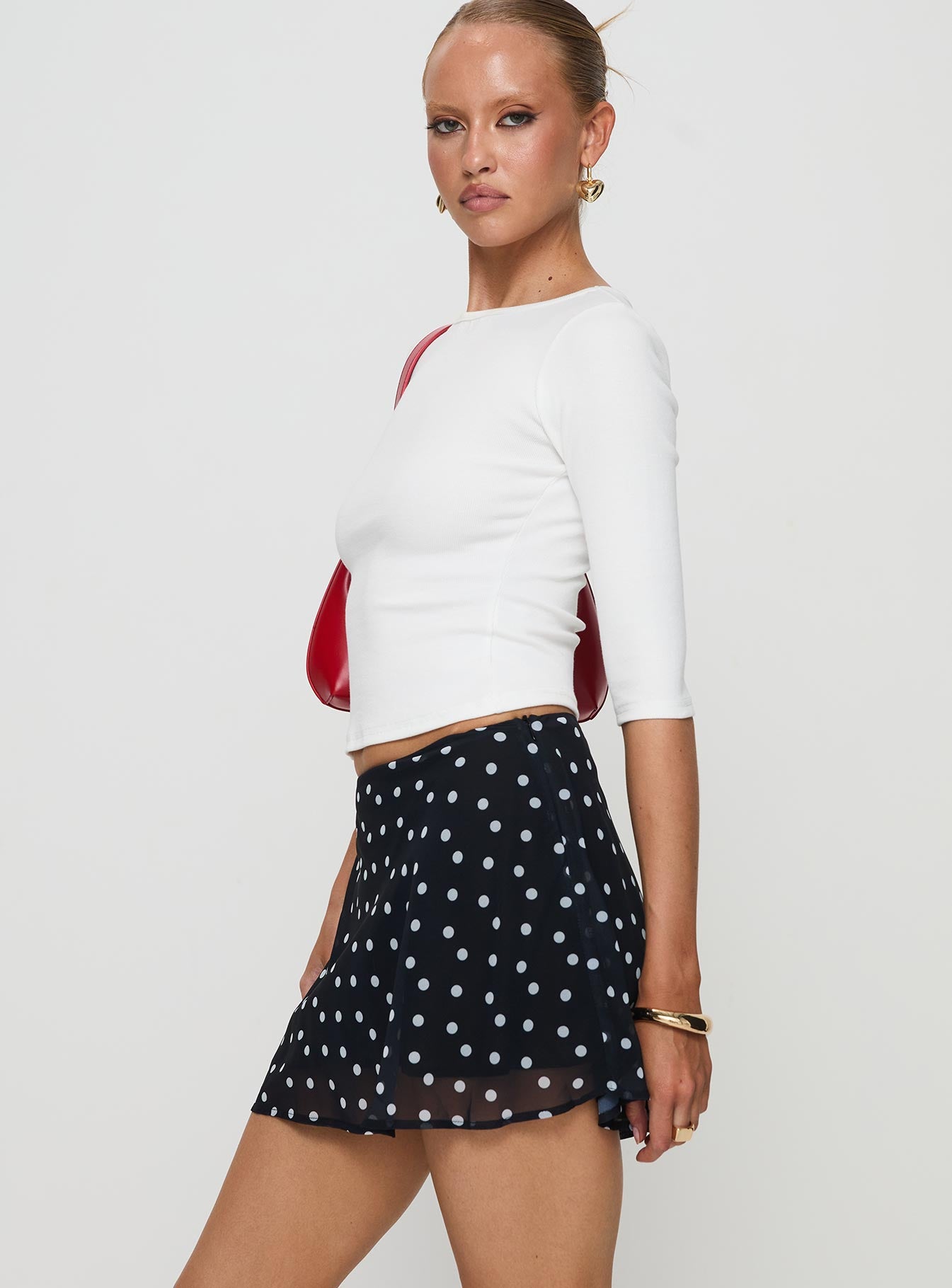   side view of model wearing Princess Polly Dapple Bias Mini Skirt Black Polka Dot Mini Skirts Skirts 