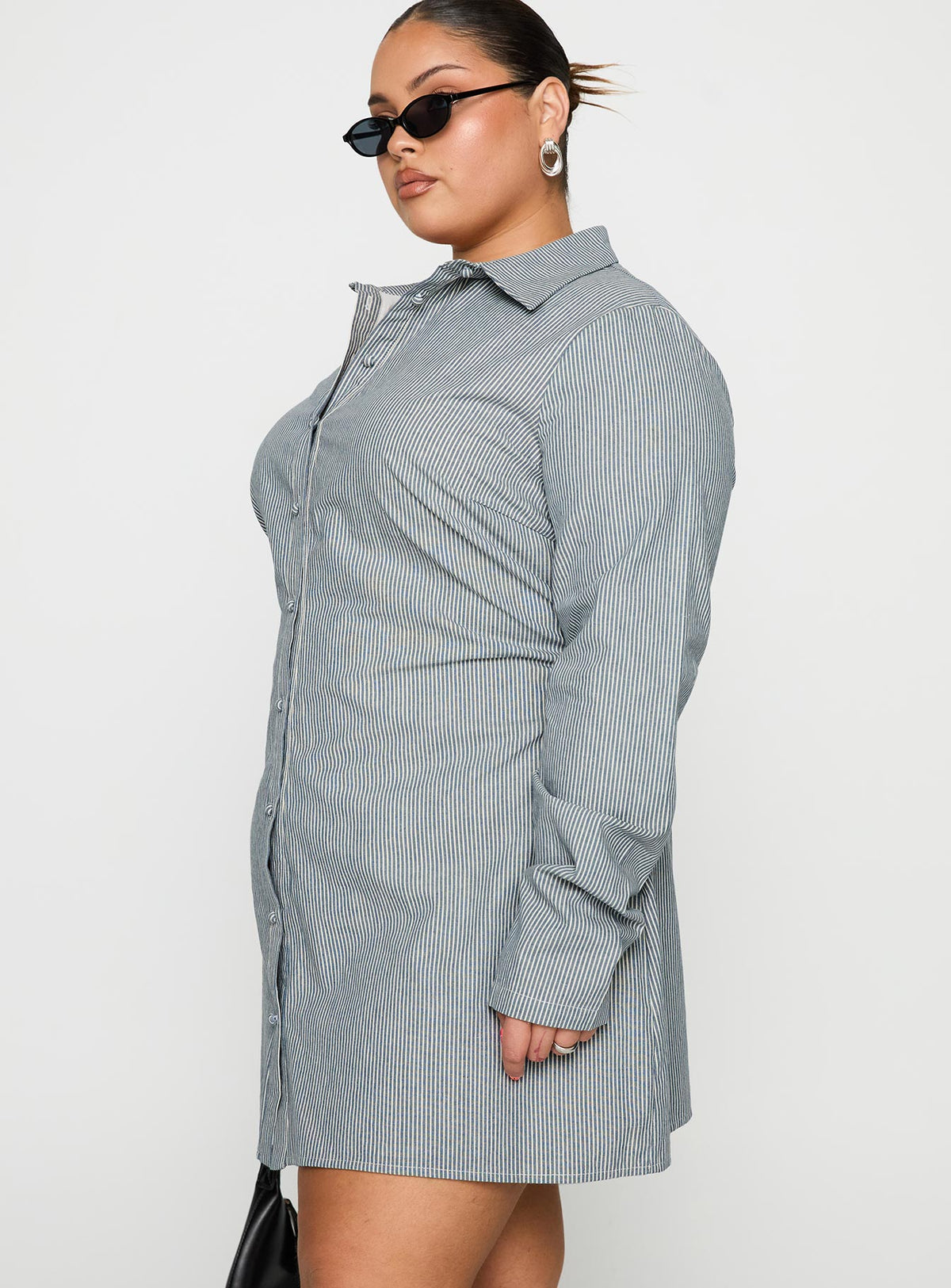 side view of model wearing Princess Polly Publicity Long Sleeve Mini Dress Blue Pinstripe Curve V-Neck 
