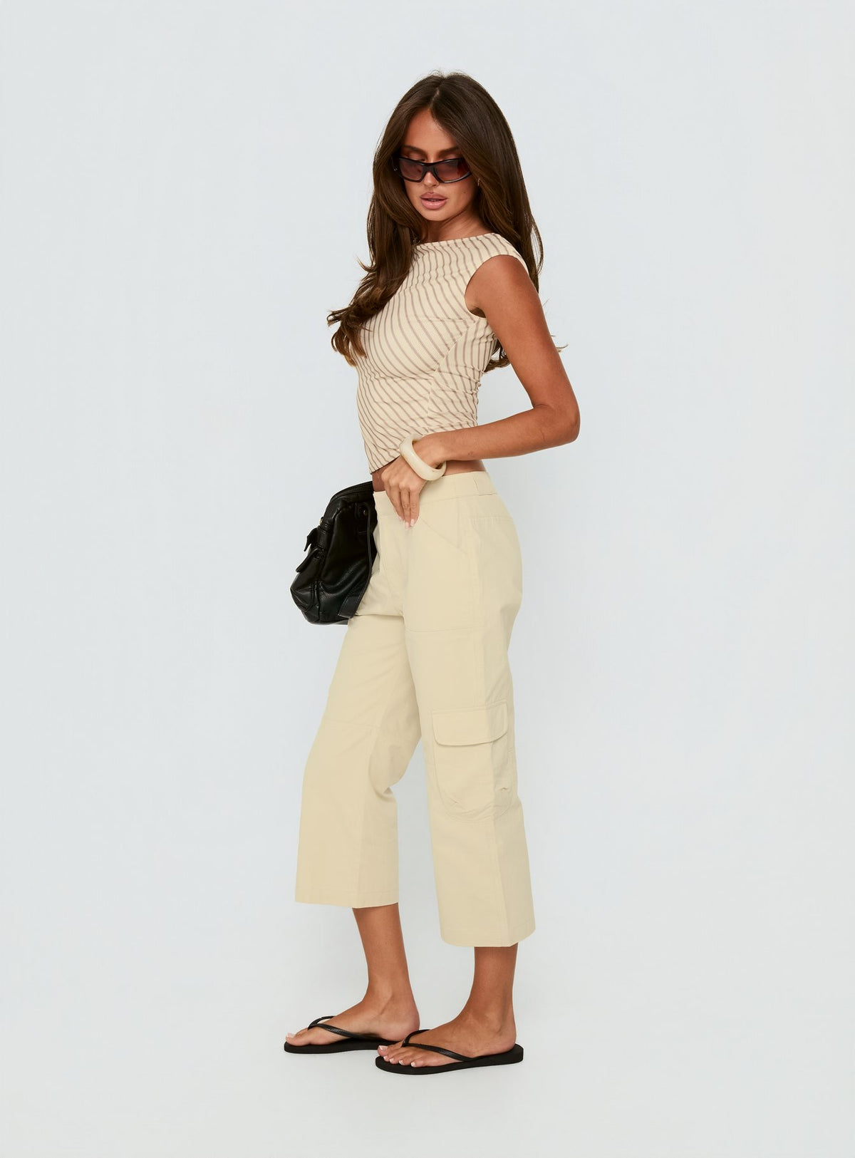 side view of model wearing Princess Polly Indee Cropped Cargo Pants Beige Mid Rise Pants Pants 