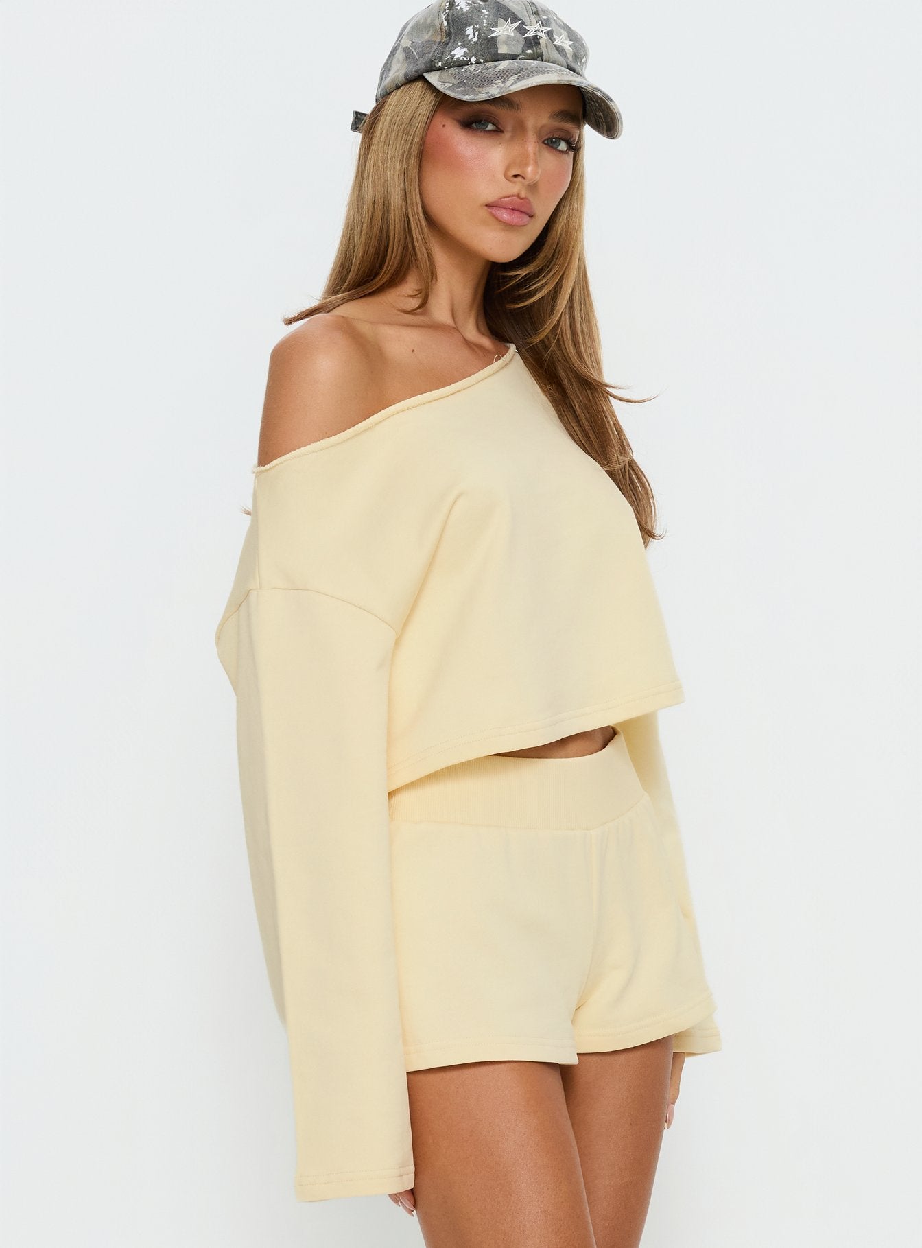 side view of model wearing Princess Polly Retreat Raw Edge Off Shoulder Jumper Buttercream cropped 