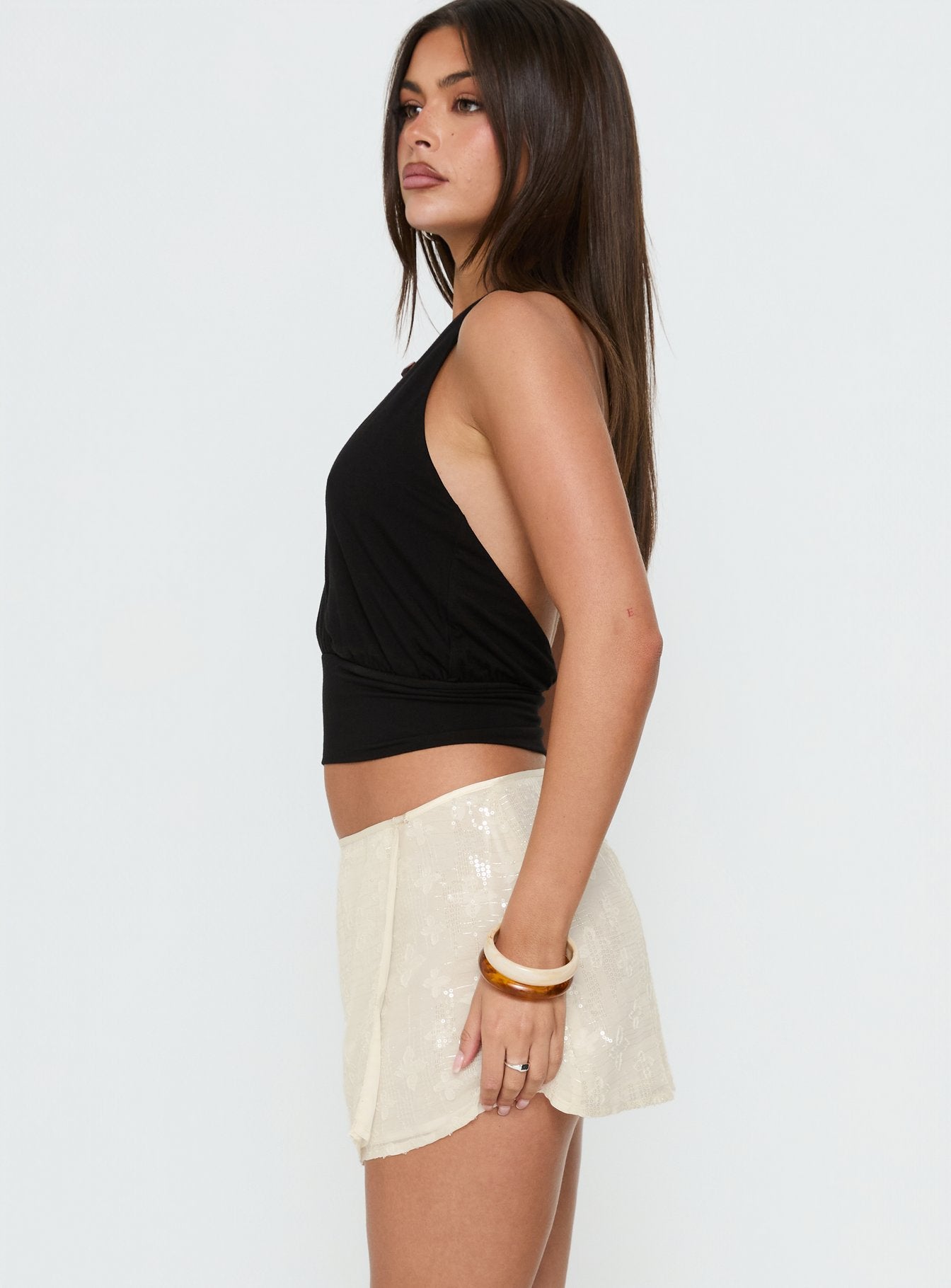 Explore the Brittain Wrap Mini Skirt Cream womens-skirts in mini length side view of model wearing Princess Polly