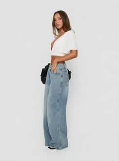 Featuring Ramos Low Rise Double Button Wide Leg Jeans Light Vintage Blue womens-jeans in low-rise side view of model wearing